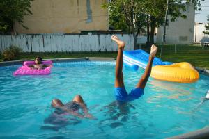 Quadrice Quarles, back left, 11 years old, Kayla Melvin, front left, 9 years old, and .Quadir Staton, front right, 10 years old,.Swim in a pool, in North Philadelphia, July 16, 2019.