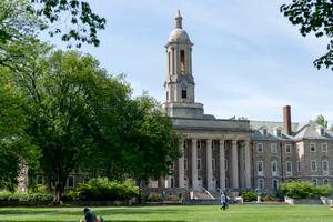 People walk across Old Main lawn on Penn State’s University Park campus in State College, Pa.