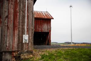 A rural building with a cell tower in the background.