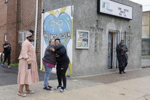 Penny Martin (left) and the Rev. Michelle Simmons, founder and executive director of Why Not Prosper, hug outside of a recovery home in Philadelphia. Simmons said the new licensing system will "make owners … step up their game."