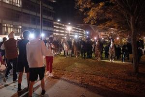 Pennsylvania State Police on horseback try to control a crowd on Penn State's campus.