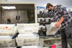 A worker organizes mail ballots in Chester County. Pennsylvania counties have been flooded with mail ballot requests, and the days-long process of counting them can’t begin until Election Day under current state law.