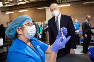 Gov. Tom Wolf observes a worker at a mass vaccination site in Lancaster County. As of March 20, there were about 97,000 people on its waitlist.
