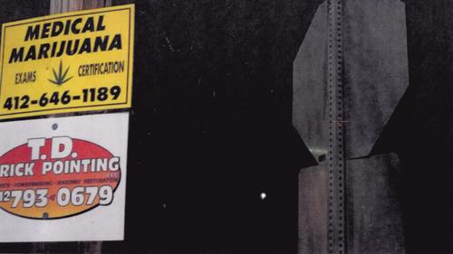 An outdoor sign promoting medical marijuana exams and certifications. An outdoor sign promoting medical marijuana exams and certifications.