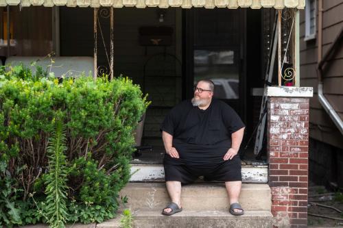 Mike Ramsey sits on the front porch of his house.