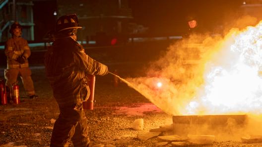 A firefighter puts out a fire during a training class.