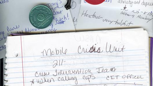 A photo of notebook paper, a cross, and sobriety chips.