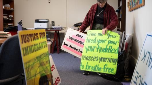 Sister Anne McCarthy with the Benedictine Sisters of Erie looks through her signs protesting President Trump’s nationwide immigration crackdown. Sister Anne McCarthy with the Benedictine Sisters of Erie looks through her signs protesting President Trump’s nationwide immigration crackdown.