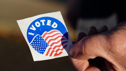 A voter holds an “I Voted” sticker at Memorial Hall in Jim Thorpe, Pennsylvania in 2022.