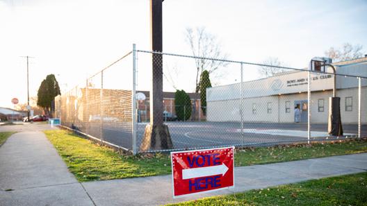 A “vote here” sign outside a polling place.