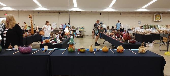 Several pieces of gourd art on a long table. Several pieces of gourd art on a long table.