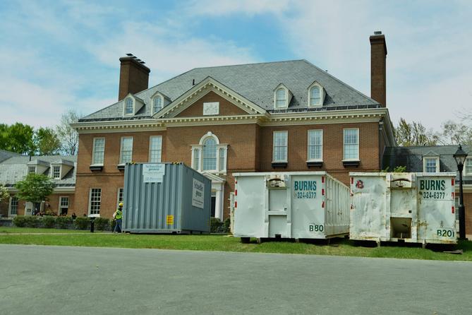 Large waste disposal bins sit out front of the Pennsylvania governor’s residence as crews work nine days after an alleged arson.