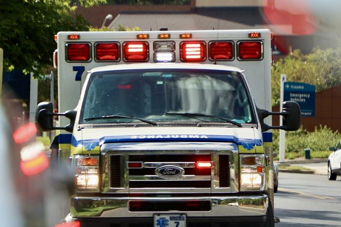 An ambulance seen head on with its lights on in the daylight. An ambulance seen head on with its lights on in the daylight.