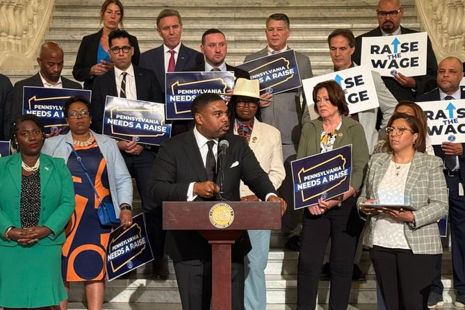 Rep. Jason Dawkins (center) speaks at a new conference urging the PA Senate to raise the minimum wage.