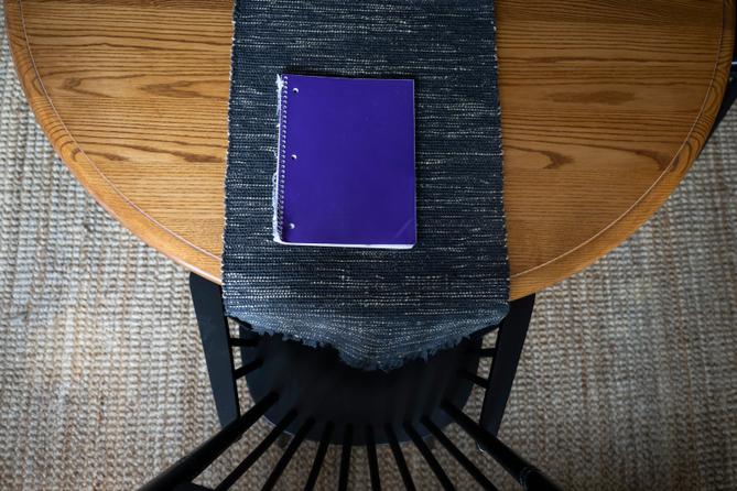 A purple notebook on a dining room table.