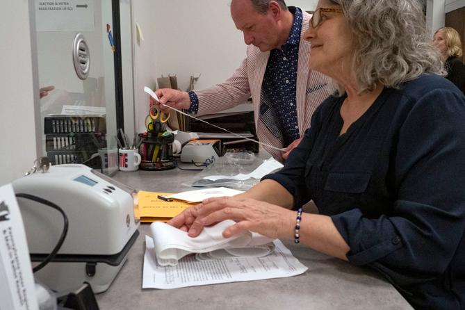 Snyder County Election Director Devin Rhoads reviews the results of a precinct’s return as election worker Stacy Guyer collects election materials.