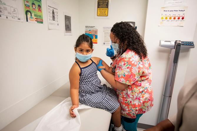 A child receives a vaccine from a nurse.