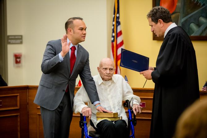 Urscheler takes the oath of office in January 2018, placing his hand on a Bible resting on his 90-year-old father’s lap.