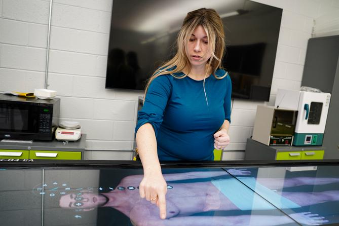 Scranton High School STEMM program supervisor Katona Miller demonstrates how to use the school's virtual autopsy table.
