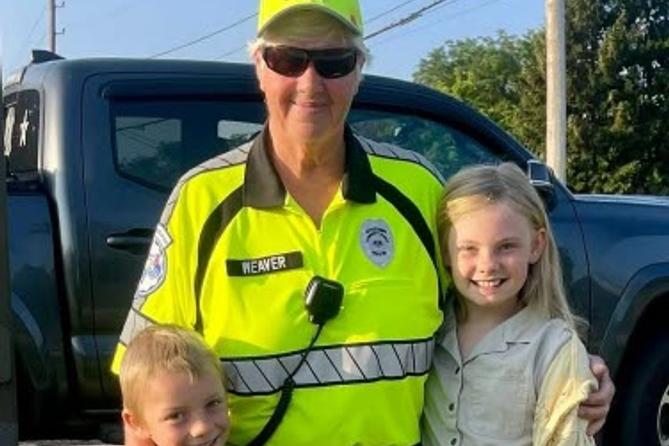 Crossing guard Jan Weaver hugs two children
