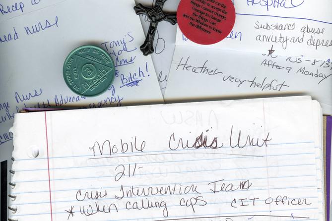 A photo of notebook paper, a cross, and sobriety chips.