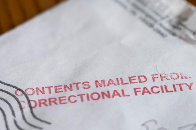 A photo of an envelope stamped in red with the words: content mailed from correctional facility