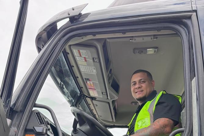 Victor Melendez sits in the cab of a tractor-trailer.