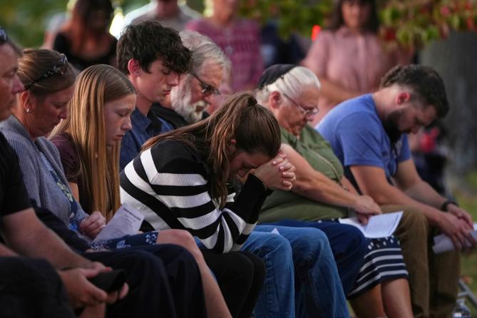 Attendees react during a vigil in Spring Grove, PA, after multiple police officers were shot and killed.