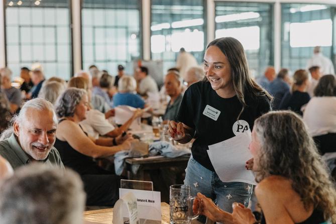 Spotlight PA Rural Affairs Reporter Marley Parish collects quiz sheets at the 2024 Clink and Think Quiz Bash Fundraiser at Axemann Brewery in Bellefonte.