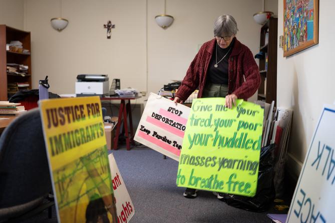 Sister Anne McCarthy with the Benedictine Sisters of Erie looks through her signs protesting President Trump’s nationwide immigration crackdown. Sister Anne McCarthy with the Benedictine Sisters of Erie looks through her signs protesting President Trump’s nationwide immigration crackdown.