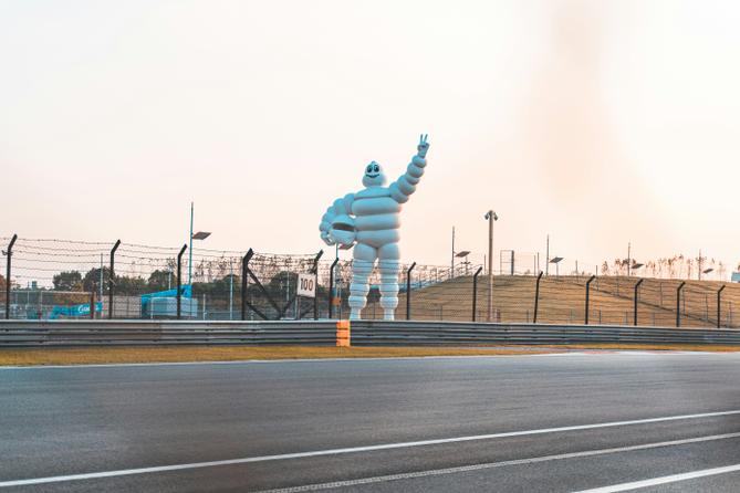 The “Michelin Man” positioned near a racetrack.