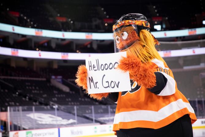 Philadelphia Flyers mascot Gritty welcoming Gov. Tom Wolf to a press conference in 2021.