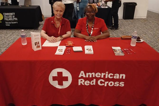 Red Cross volunteer Mary Harper (right) sits at a table Red Cross volunteer Mary Harper (right) sits at a table
