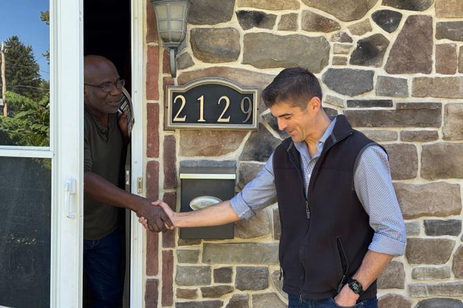 Ryan Crosswell (right), a Democratic candidate for Pennsylvania’s 7th congressional district, speaks to a man in Easton, PA.