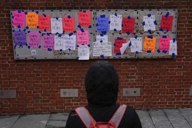 A person views posted signs on the locations of the now removed explanatory panels that were part of an exhibit on slavery at President's House Site in Philadelphia, Jan. 23, 2026.