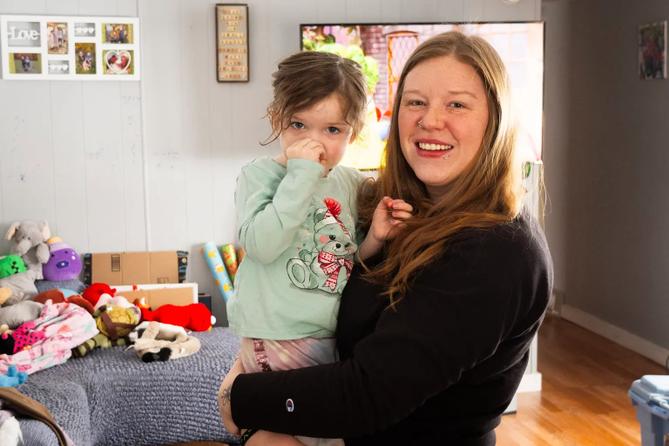 Candace May holds her daughter, Nova, in their home at Valley View Estates. May and other residents are making plans for where they will live after their eviction in April.