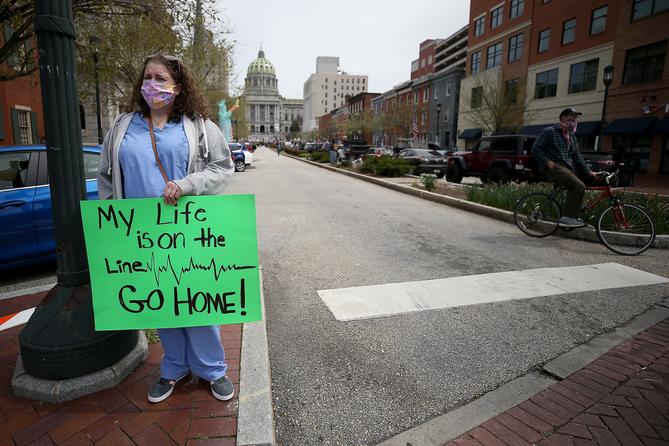 Nurse Erica Zimmerman, of southwestern Pennsylvania, urges protesters who gathered outside the Capitol Complex to go home during a rally in Harrisburg, PA on April 20, 2020. The protesters are calling for Gov. Wolf to reopen up the state's economy during the coronavirus outbreak.