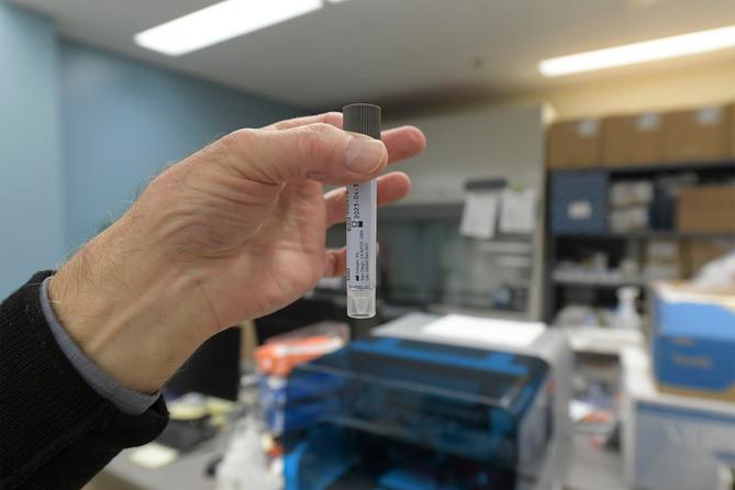 Robert Wadowsky, Allegheny County public health lab director, holds a vial used to test samples for COVID-19.