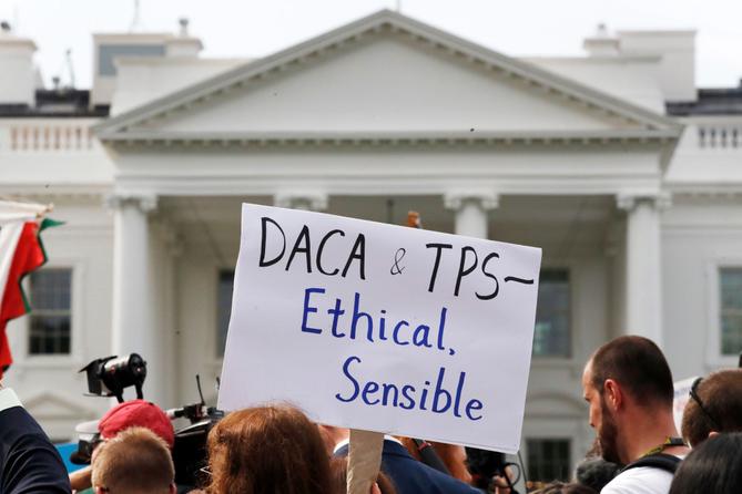 A person holds up a sign in support of the Deferred Action for Childhood Arrivals, known as DACA, and Temporary Protected Status programs during a rally at the White House, Sept. 5, 2017.