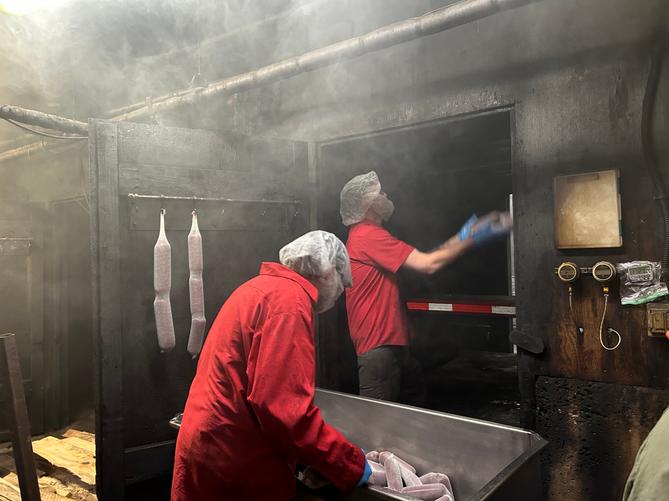 Employees at Seltzer’s throw uncooked Lebanon bologna up to another employee in the smokehouse, who hangs them from the rafters. Employees at Seltzer’s throw uncooked Lebanon bologna up to another employee in the smokehouse, who hangs them from the rafters.